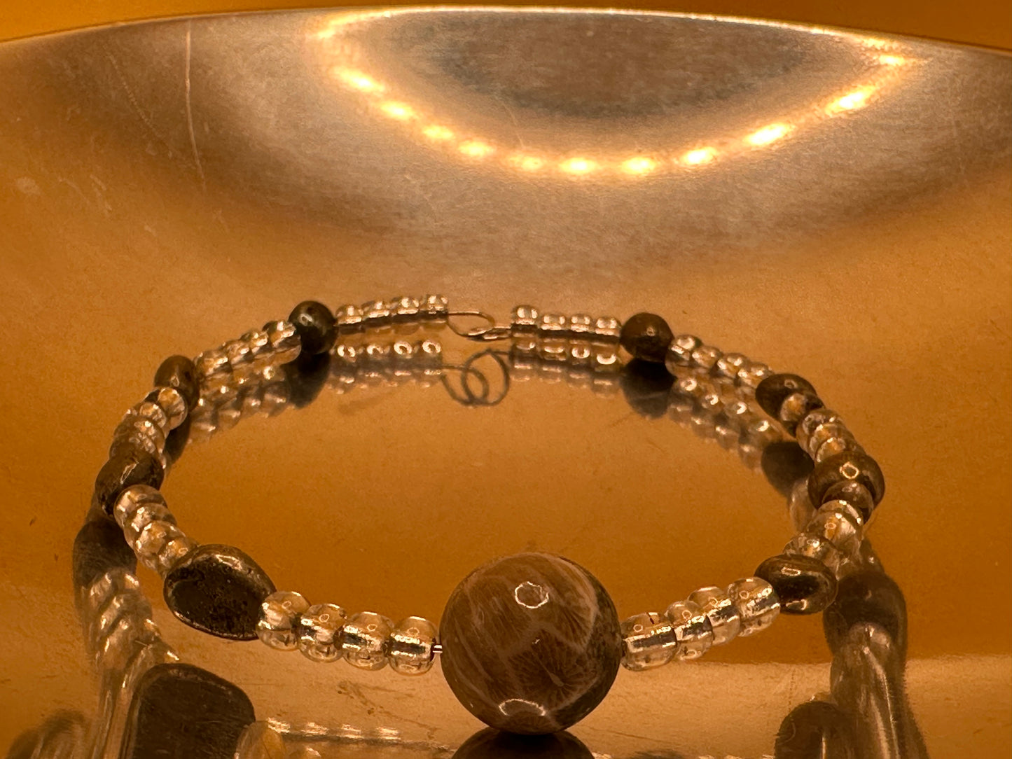 Memory wire bracelet with gray stone and clear accent beads with Petoskey Stone focal bead.