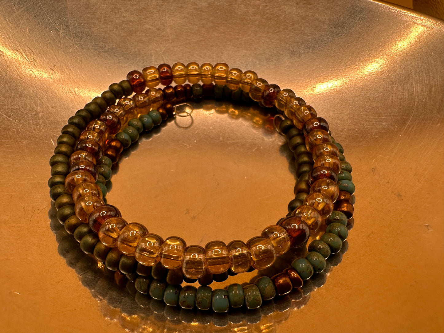 Memory wire wrap bracelet with Picasso beads, amber, bronze and metallic green tone beads.