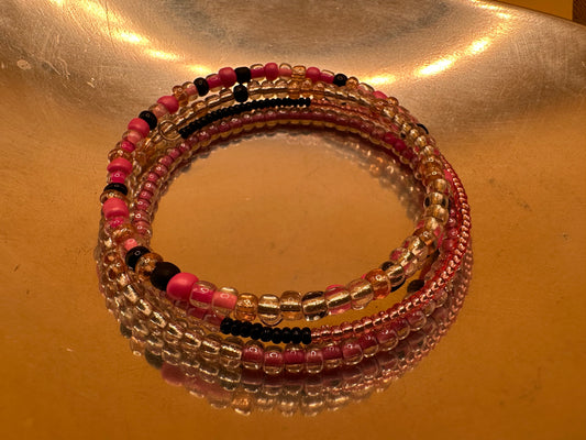 Memory wire wrap bracelet featuring pink, peach and black glass beads.