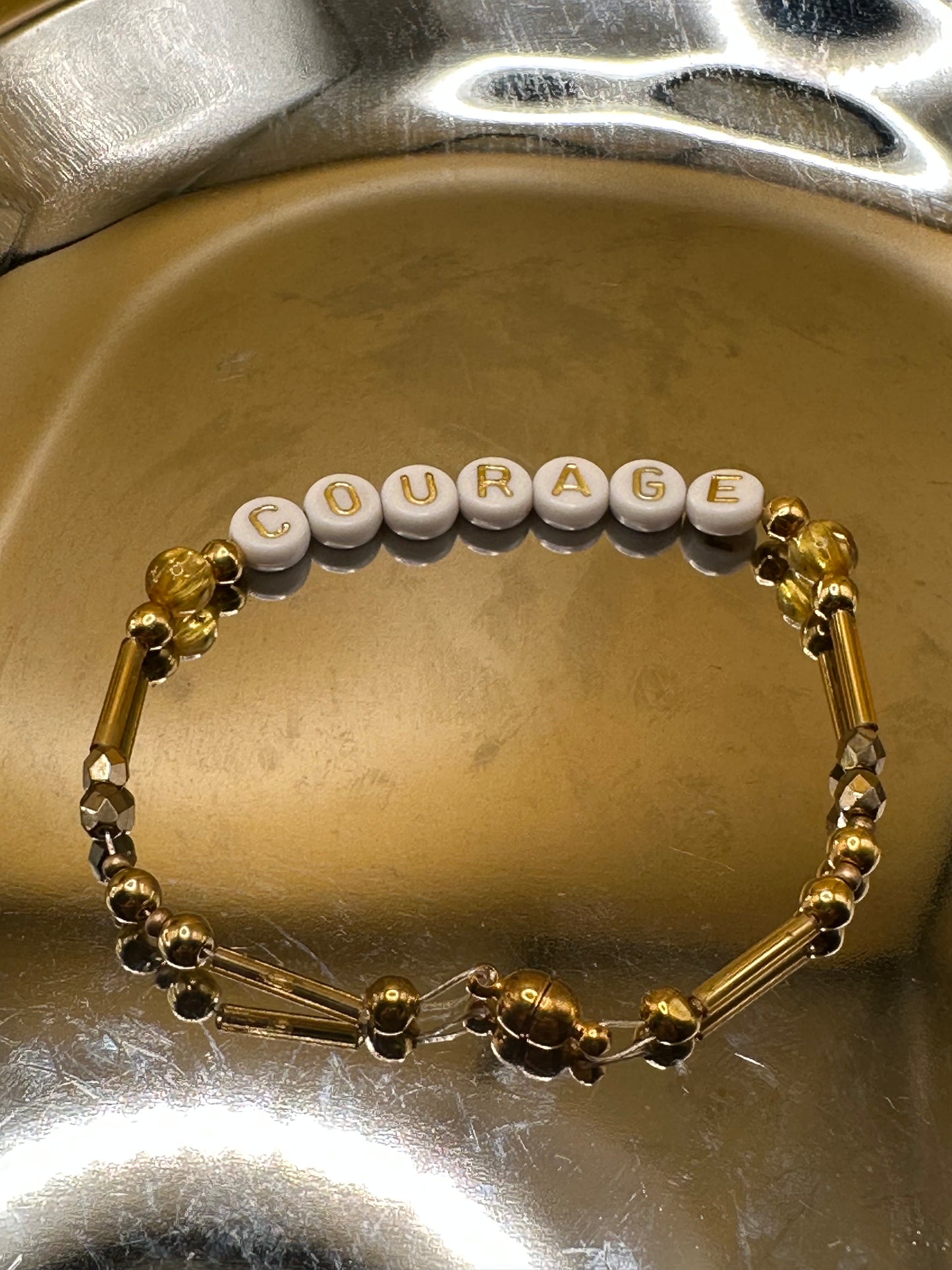 Gold toned "Courage" bracelet with magnetic clasp.